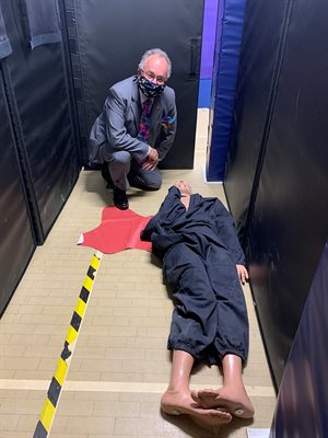 PCC Rupert Matthews kneeling by a dummy on the floor surrounded by black screens