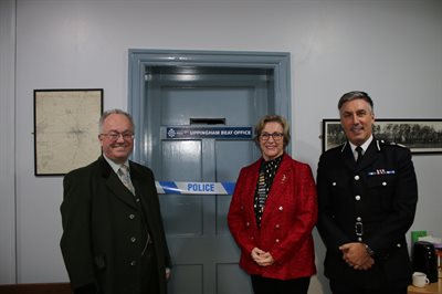 Image of the Commissioner, the Mayor and the Chief Constable with ribbon over door for cutting
