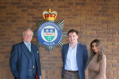 PCC Rupert Mathews with Oliver Bryan and Neetu Squire next to Force Crest on wall