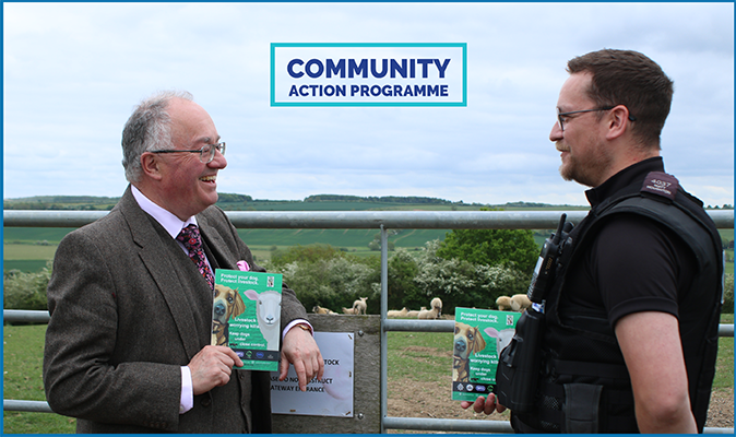 Commissioner and police officer by field gate with sheep in background